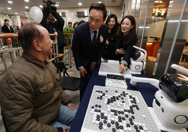 은곡시니어센터에서 로봇과 바둑을 두는 어르신과 인사하는 조성명 구청장