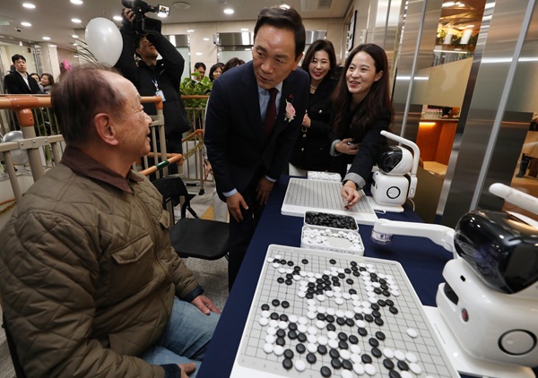 은곡시니어센터에서 로봇과 바둑을 두는 어르신과 인사하는 조성명 구청장.